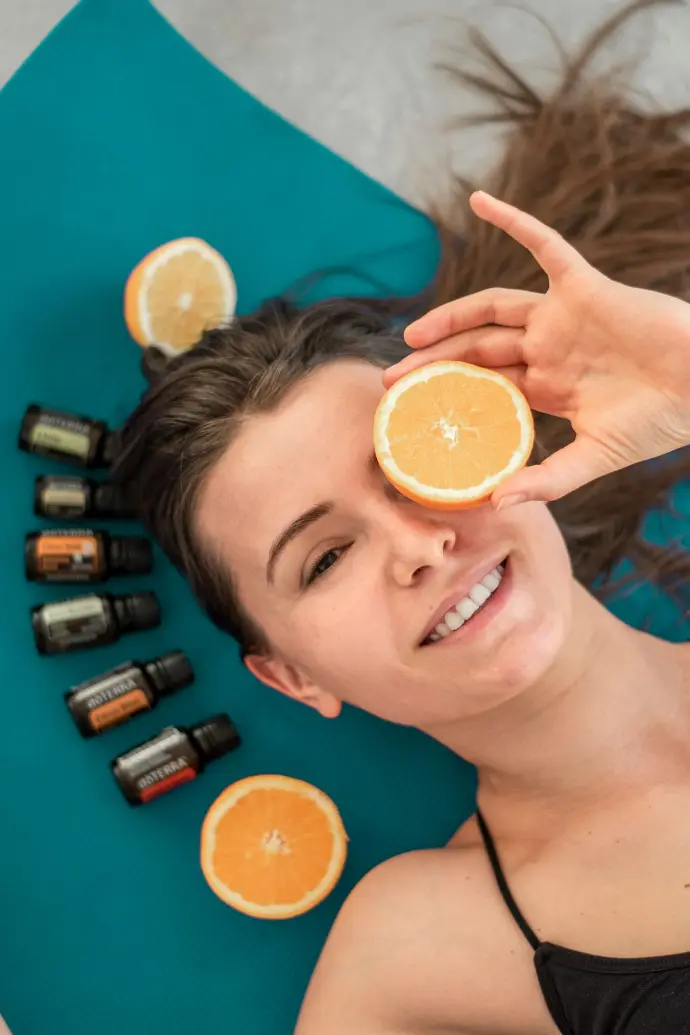 a woman laying on a mat holding an orange